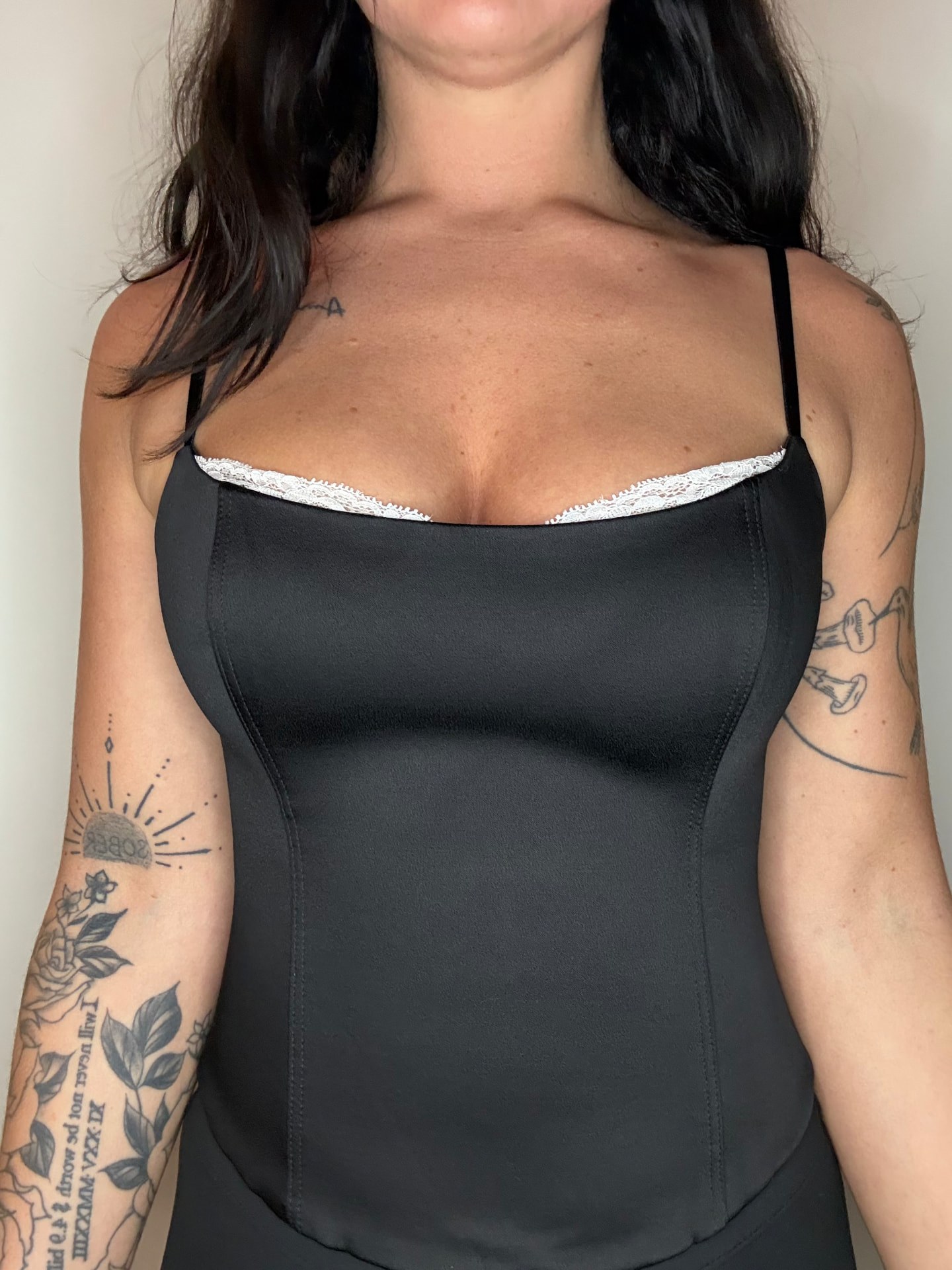 Close-up of the bustier's white lace trim against the black satin.