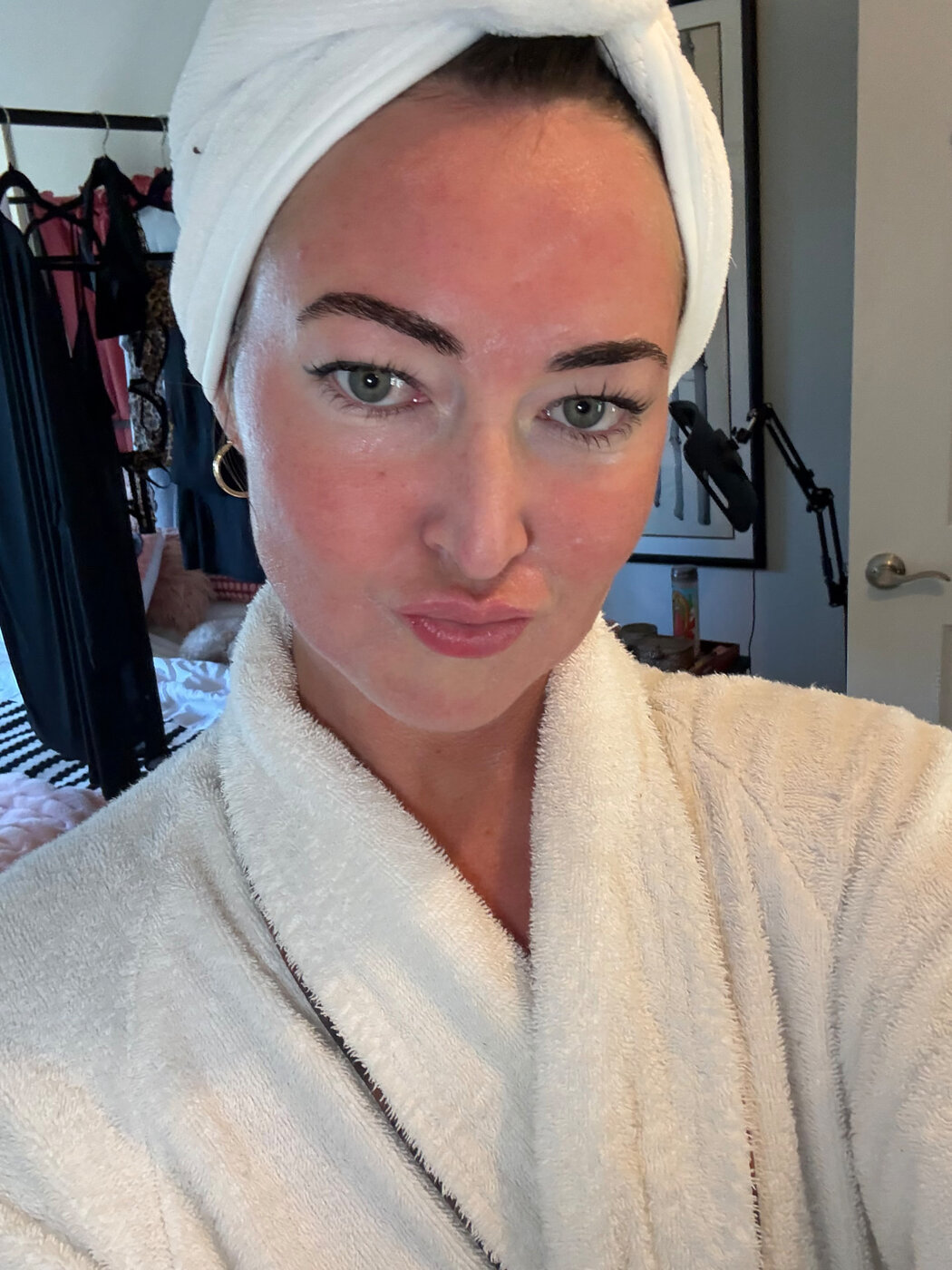 After the lash lift, in a white robe and hair towel.